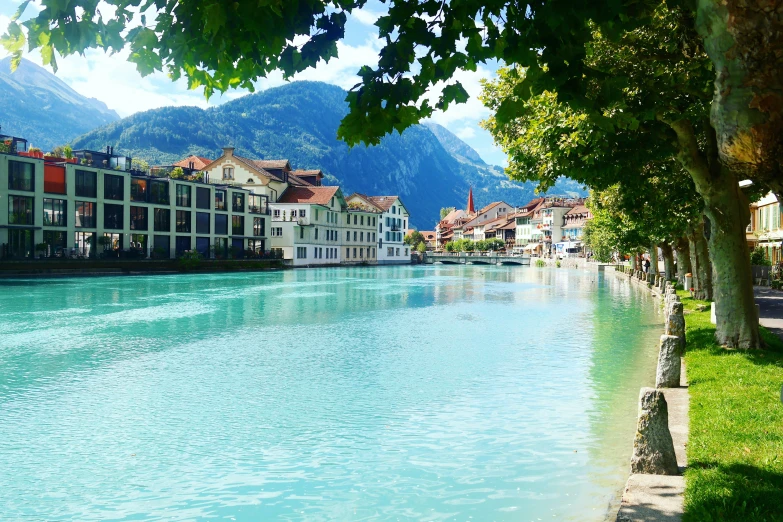 the beautiful blue water of a river running between a city with mountains