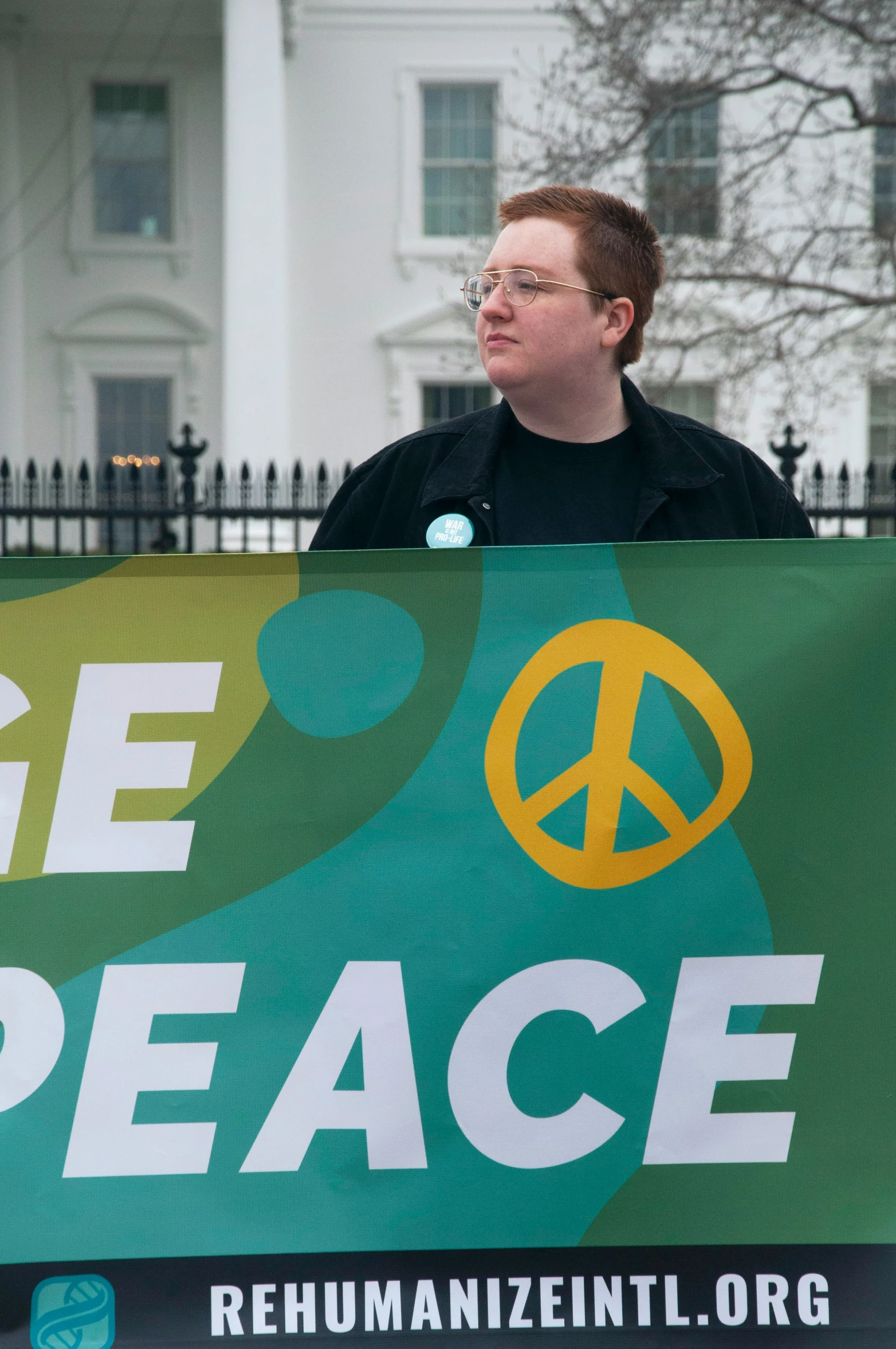 a man holding a sign reading we see peace