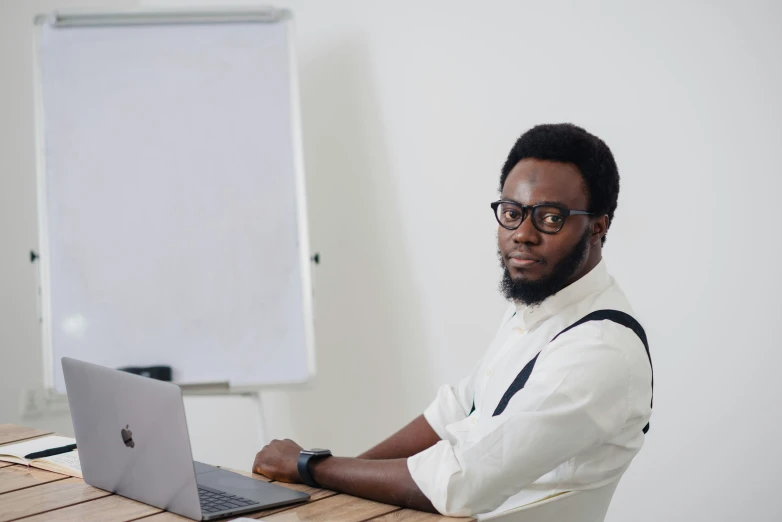 a man in glasses and a beard works on his laptop