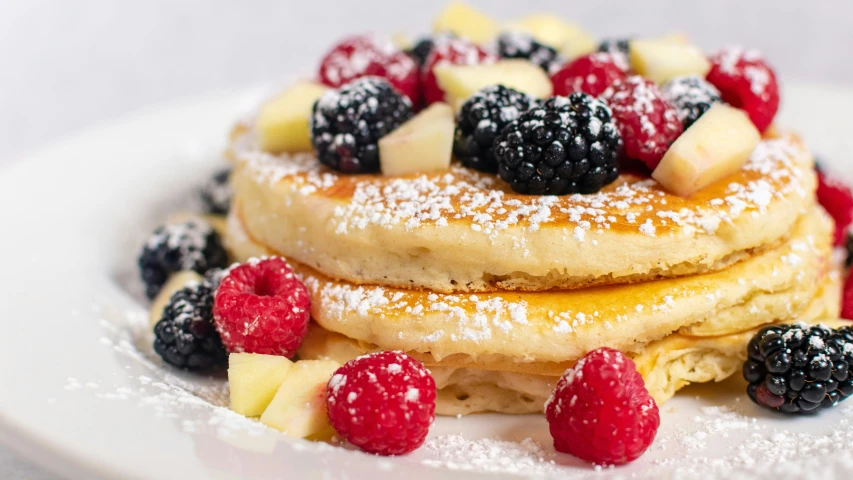 pancakes with fruit toppings are arranged in a row