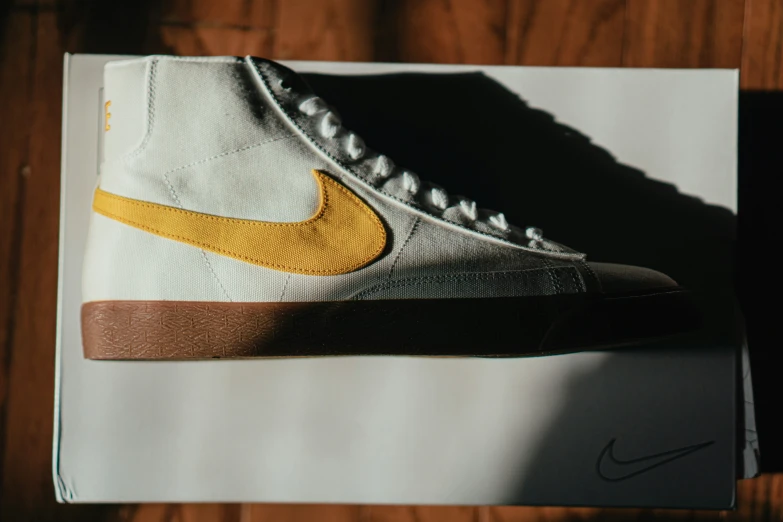 a white and yellow nike shoe sitting on top of paper