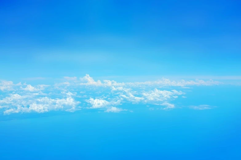 an aerial view looking out a plane window over the blue skies