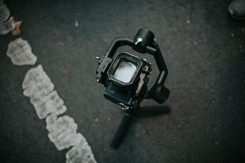 a camera sits on the ground next to a persons foot