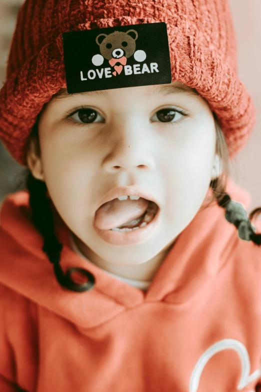 a child wearing a hat and pulling its tongue out