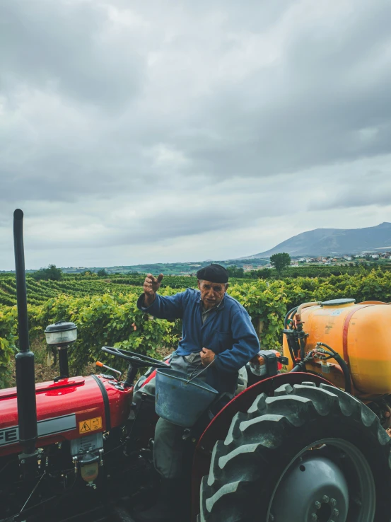 a man sits in his tractor with his hand up to the camera