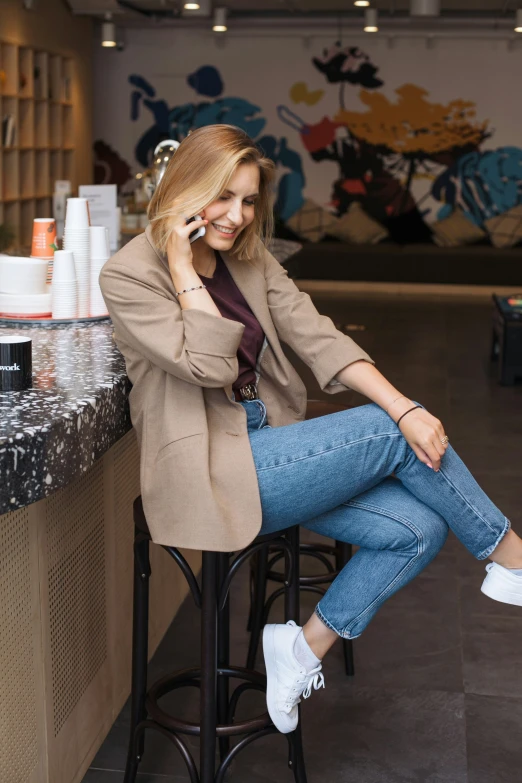 a woman sits at a bar and talks on a cell phone