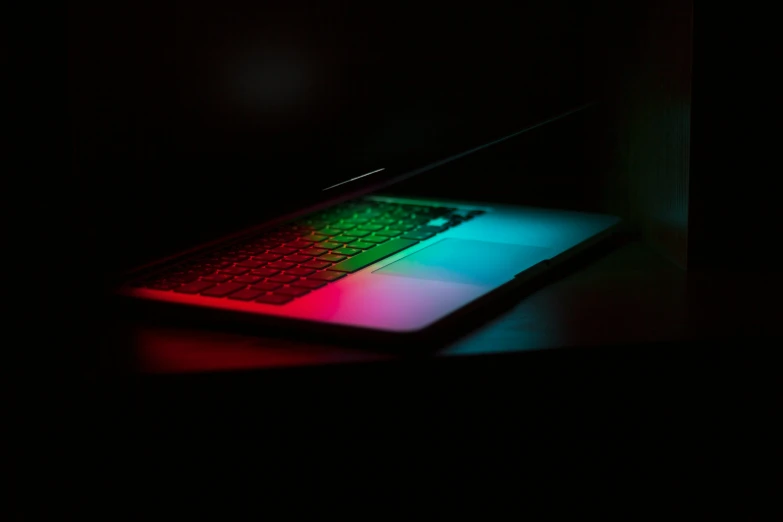 laptop glowing with colored keyboard sitting on a table