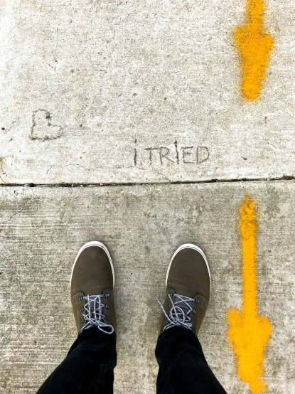 a person standing on concrete with his feet crossed