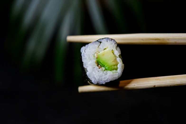 some pieces of sushi being held together by chopsticks