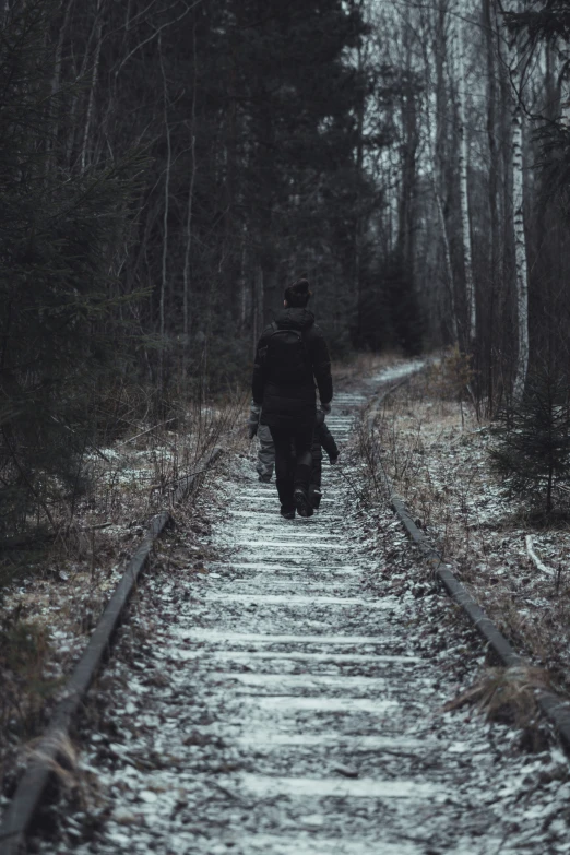 a man that is walking down some tracks