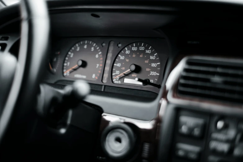 the dashboard gauges of an suv, with the air conditioning vent open