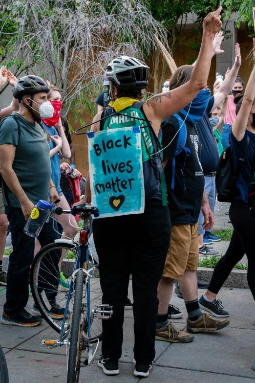 several people standing with signs and bicycles on the street