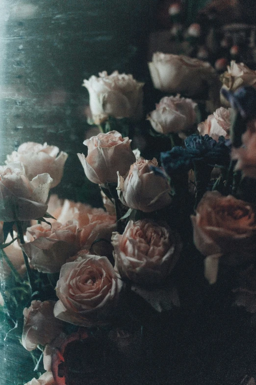 a bouquet of roses in pastel pinks in an old glass bowl