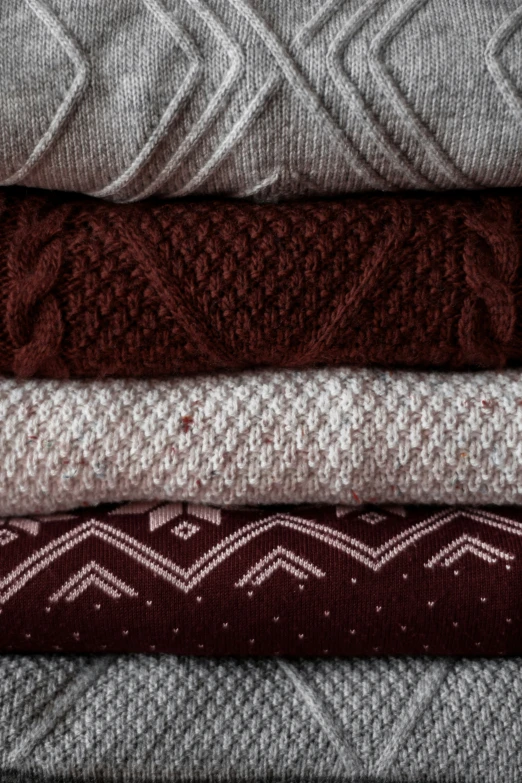 a stack of different sweaters on top of each other