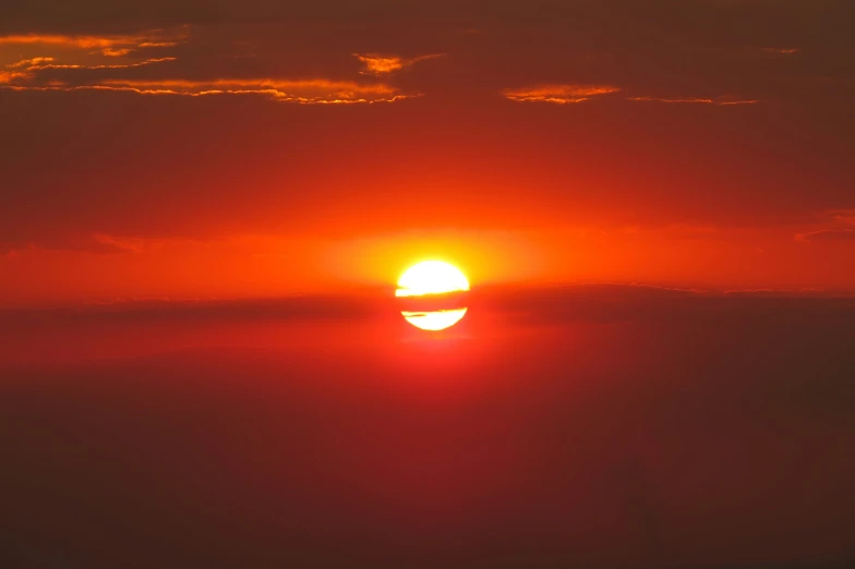 the sun sets in the distance over the clouds