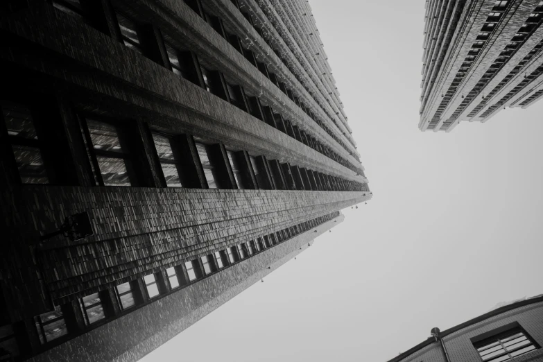 two tall buildings next to each other with sky in background