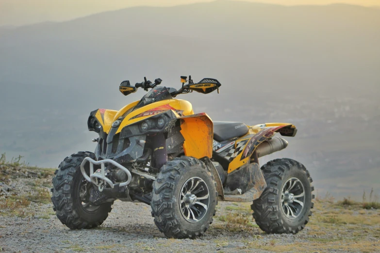 a yellow four - wheeler is on the side of a road