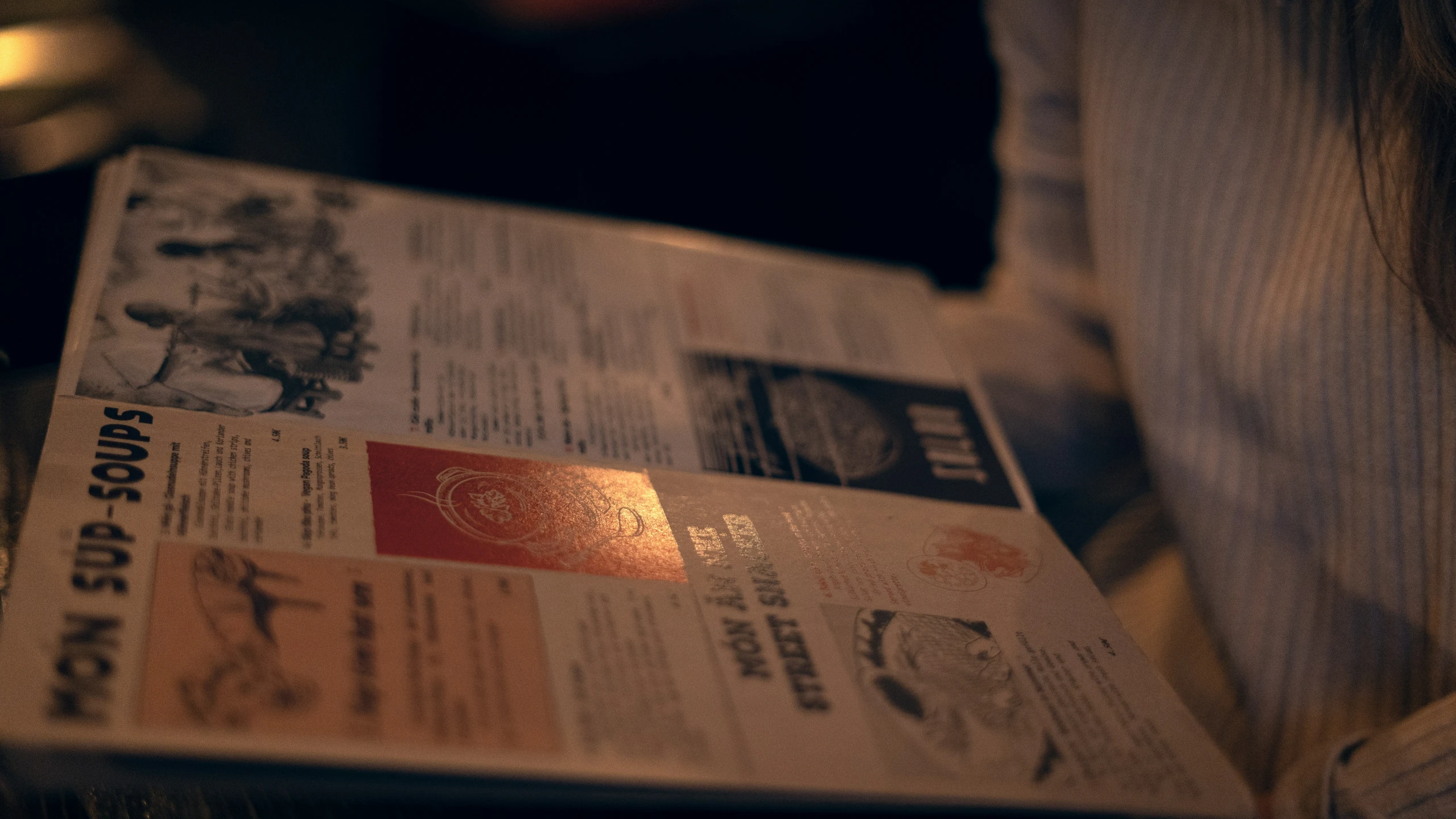 newspapers are stacked on top of a small wooden table