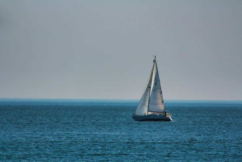 a sailboat is in the blue water with another sailboat