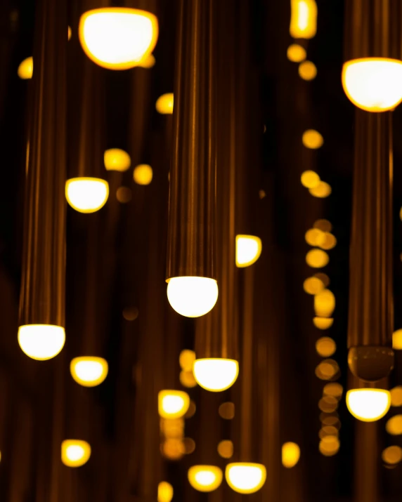 lights hanging down from the ceiling that have yellow and white shades