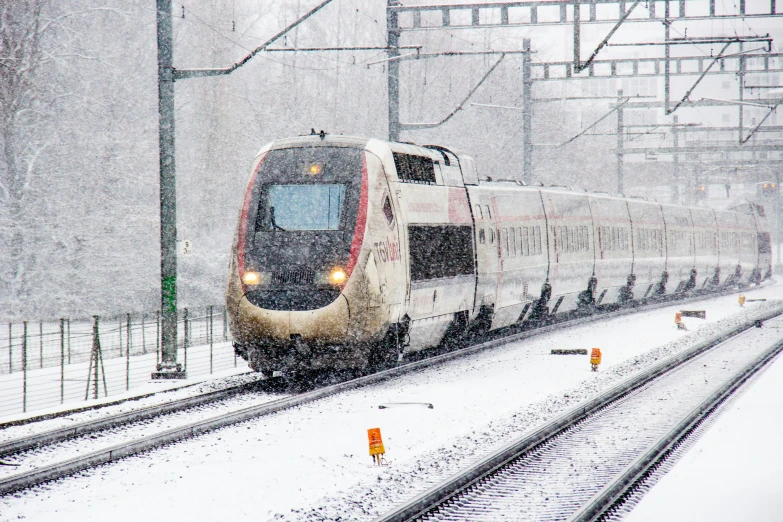 a train is on a train track in the snow