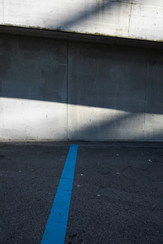 a blue street sign at the end of an empty parking lot