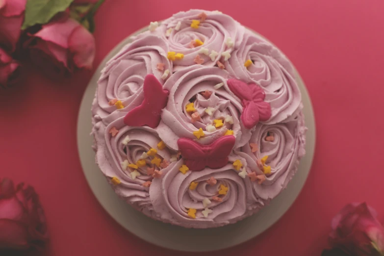 pink frosted cake with a erfly decoration on top