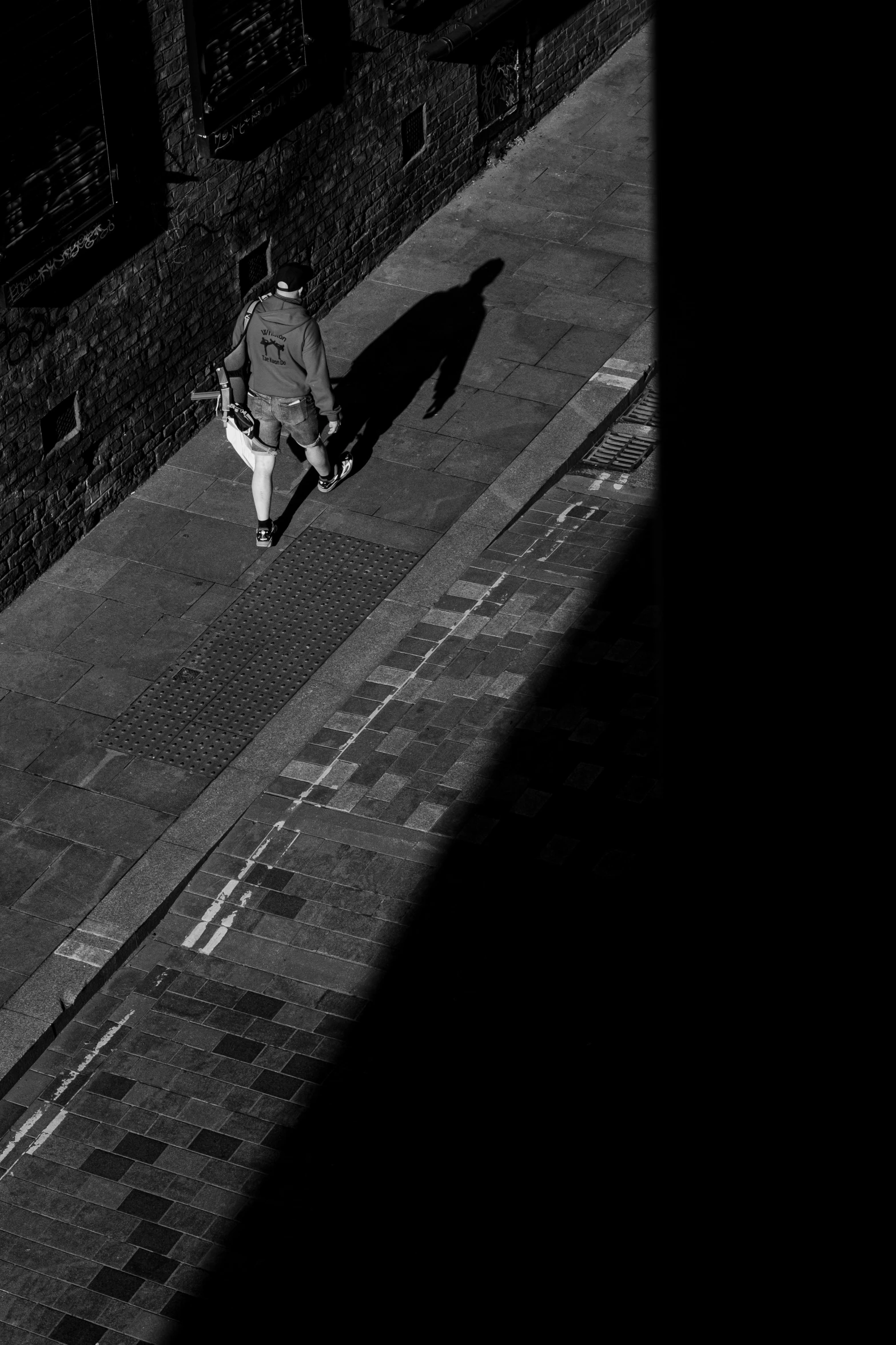 black and white pograph of person walking down street