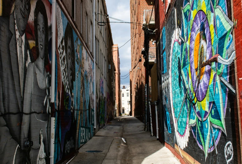 a narrow, empty street with graffitti on it