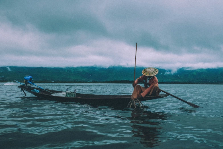 an old man in a straw hat sitting on a boat