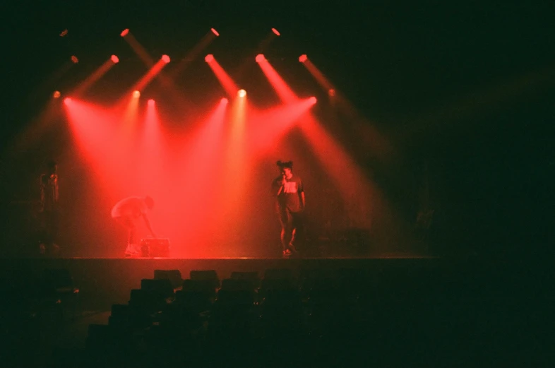 a man is standing on stage with two lights behind him