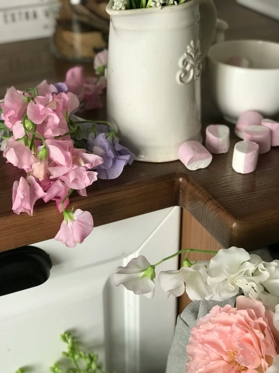 a vase with many flowers sitting on the counter