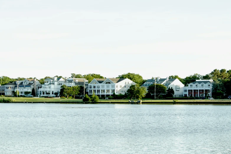 a body of water in front of some houses and trees