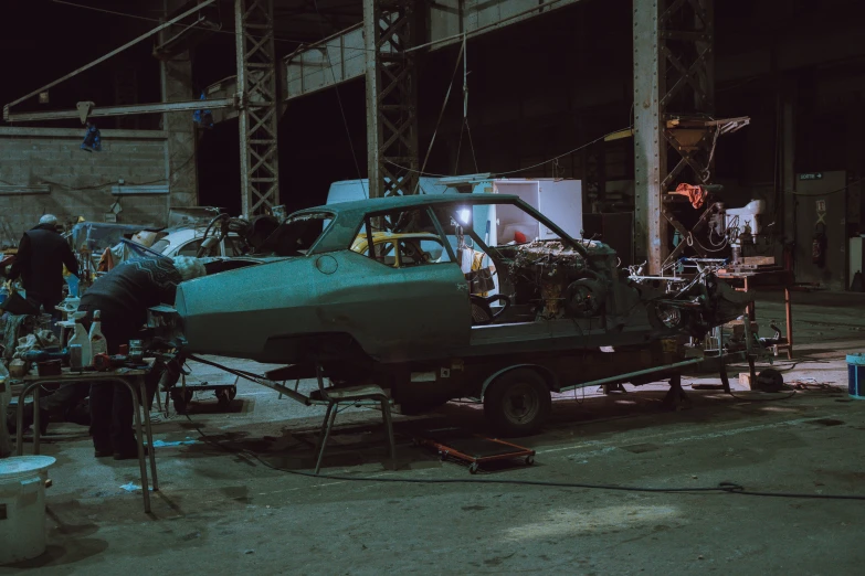 a green airplane parked next to a group of people