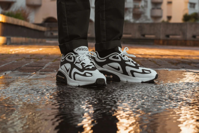 a person in a white and black sneaker on pavement