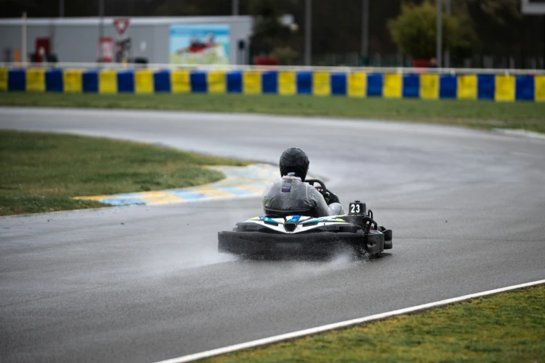 a person is racing on a kart in the rain