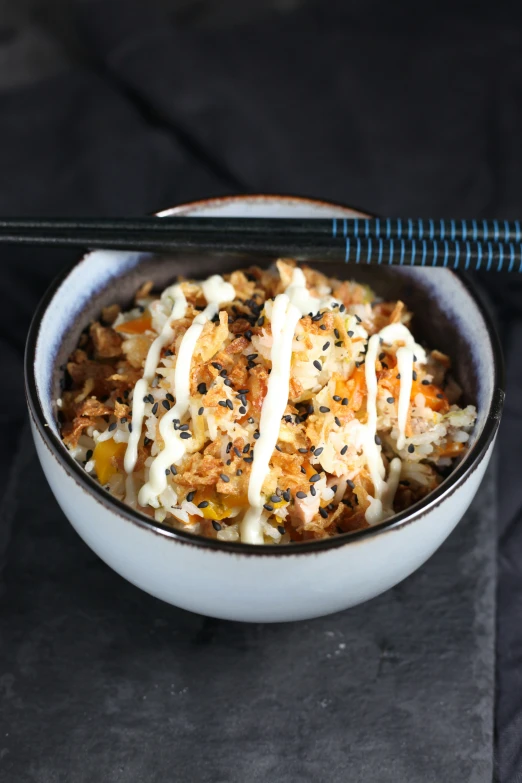 a bowl full of rice and noodles topped with mayo