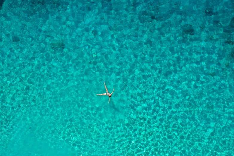 an aerial view of a person swimming in the ocean