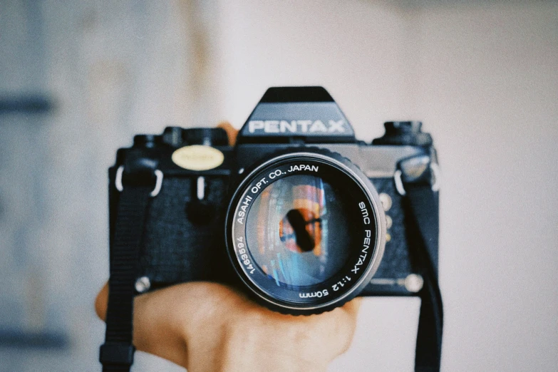 a man holding up a camera with a lens in his hand