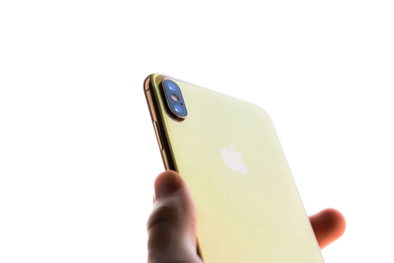 someone holds up the iphone x in their hand