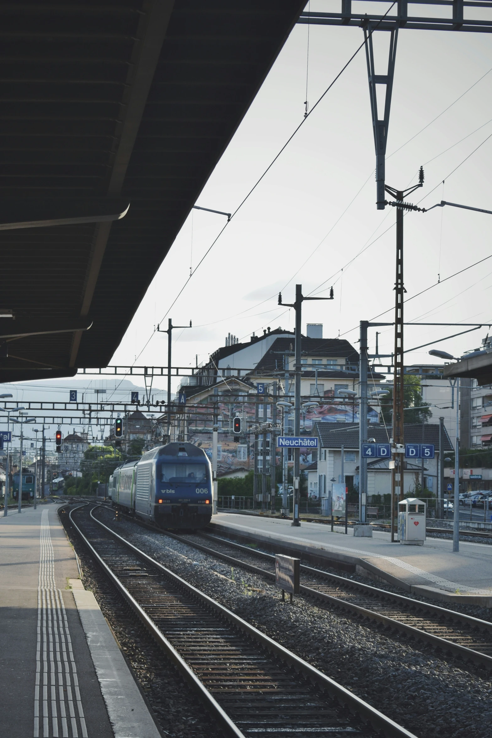 a train on the tracks with an industrial area behind