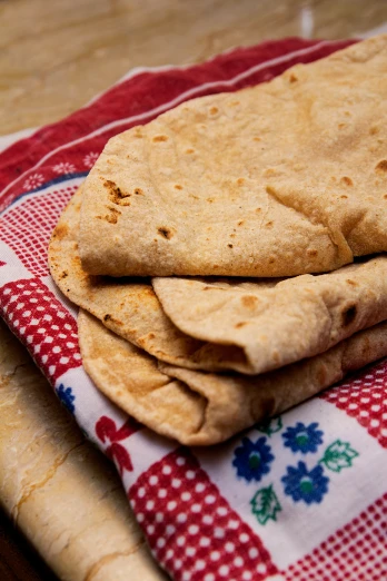 three quesadillas stacked on a red and white table cloth