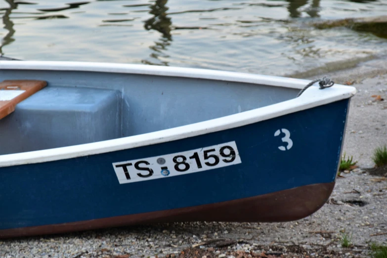 a small blue and white boat on a beach