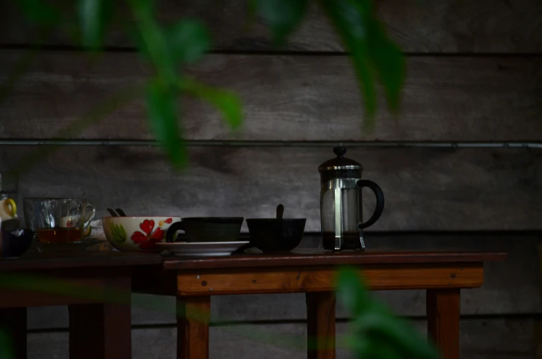 table with food and cups on it next to wooden planks