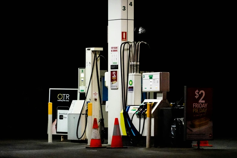 a group of gas pumps with a lit light