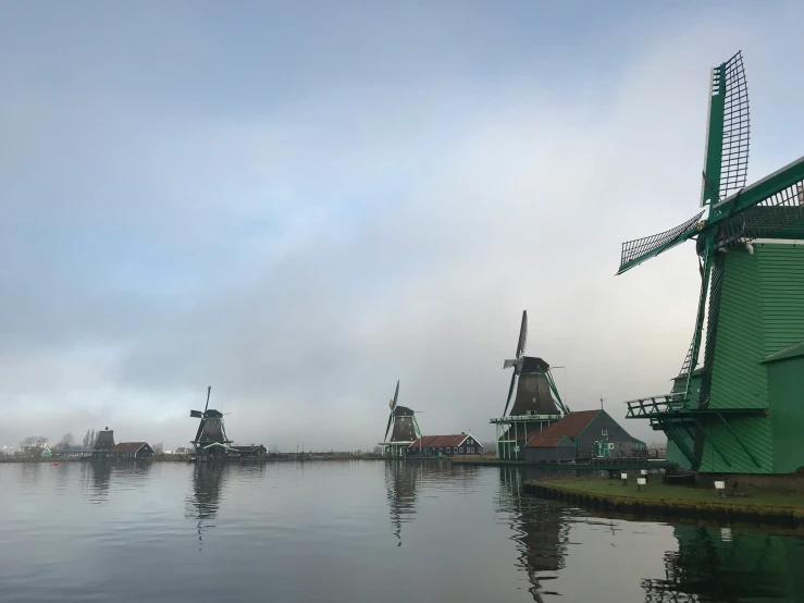 a group of windmills sit on top of the water