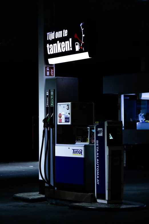 an empty gas pump with neon sign above it