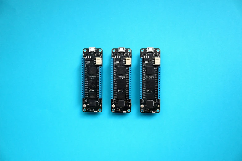 three circuit boards sitting on top of a blue table