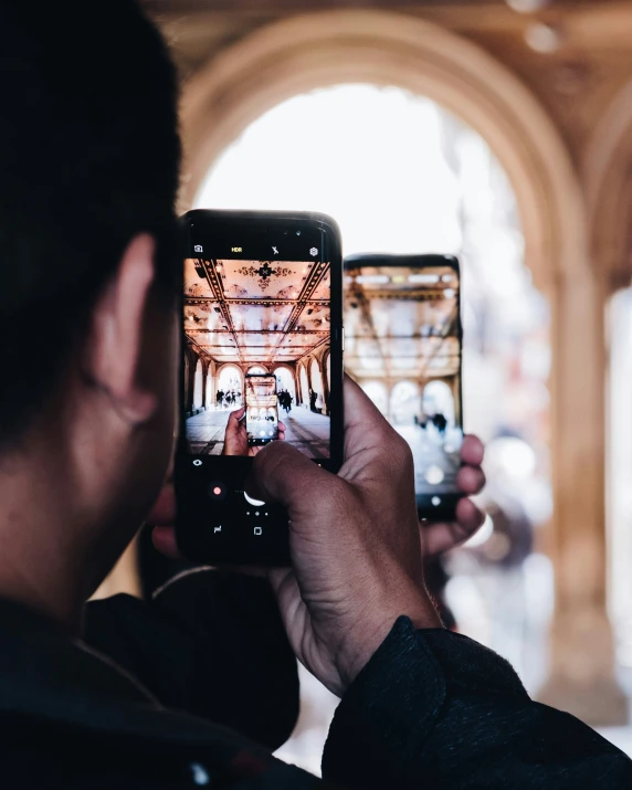 a person taking a picture of the entrance to an old building