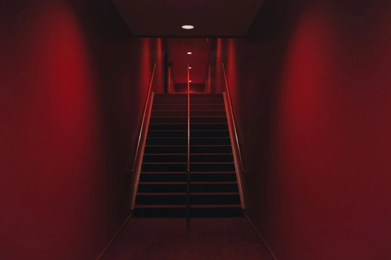 an empty staircase that looks great and has red light at the end